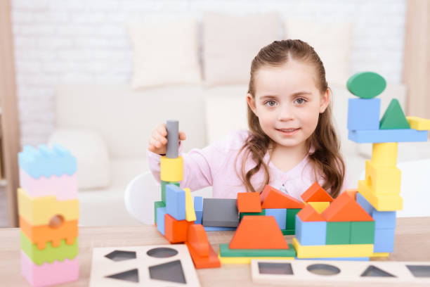istock A little girl is playing with colorful cubes. 906147414
