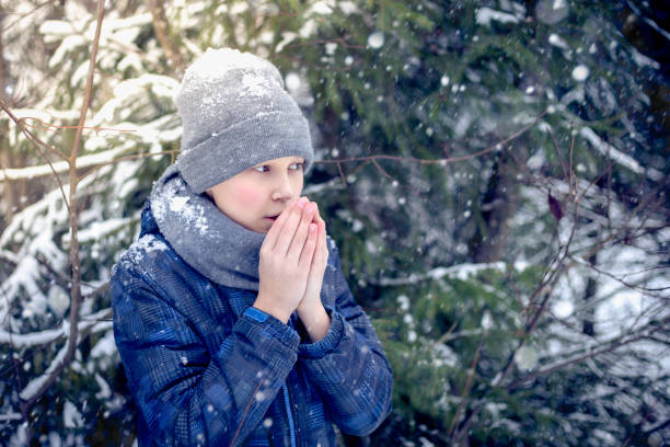 istock A boy warms his hands from the cold in winter 906151870