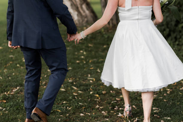 istock Mid section of newlywed couple holding hands 906172730