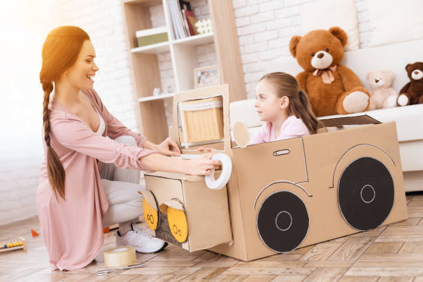 a little girl with her mother is playing with a toy car. - family mother domestic life food imagens e fotografias de stock