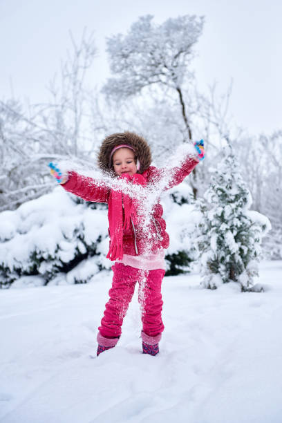 istock Little girl in red clothes, playing on snow 906190012