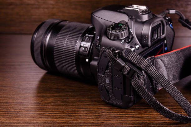 istock Modern dslr camera on the dark wooden table 906200776