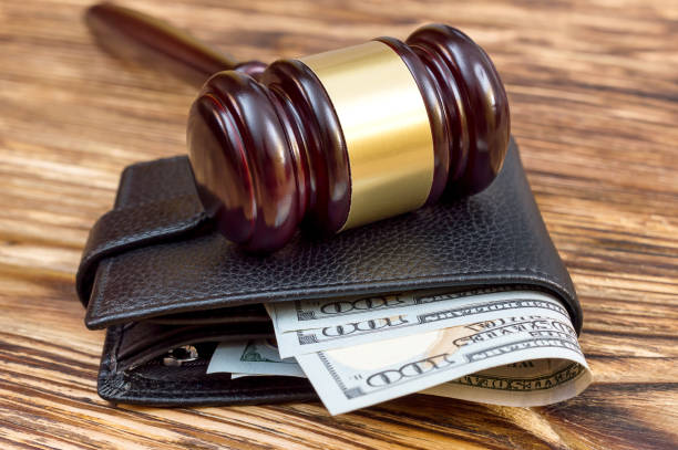 istock Gavel and wallet with money on the table. 906225412