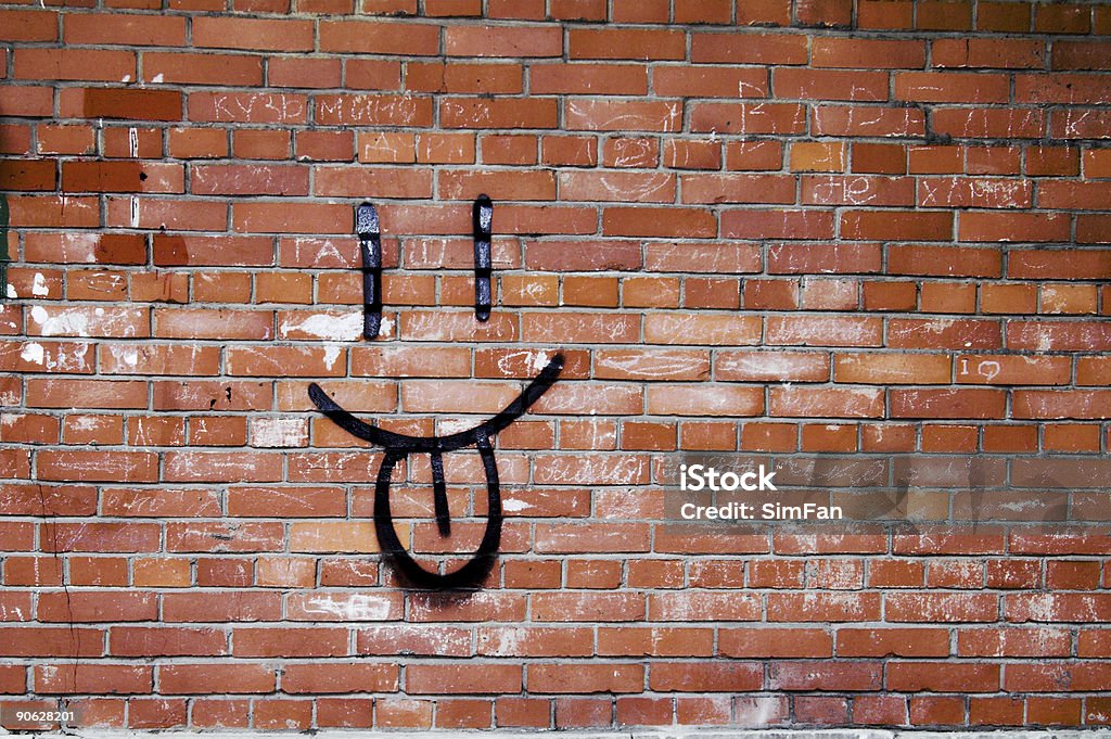 Кирпичная стена и улыбаться Граффити - Стоковые фото Высовывать язык роялти-фри
