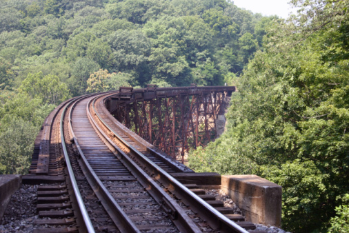 Fairfax Station, Virginia, USA - March 14, 2024: A Virginia Railway Express (VRE) commuter train travels on a curve heading Westbound on a sunny afternoon.