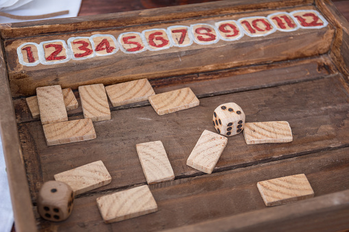 Antique Table Game with Dices and Rectangular Wooden Pieces on Board.