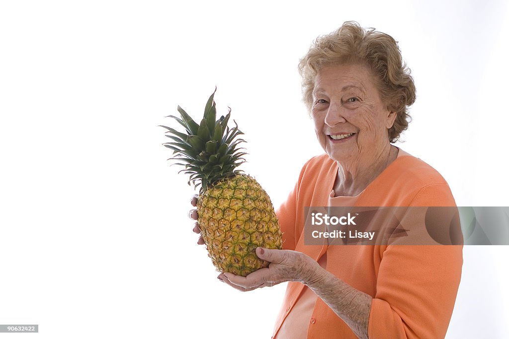 Kobieta gospodarstwa ananasa - Zbiór zdjęć royalty-free (Aktywni seniorzy)