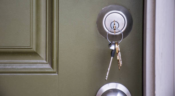 close up on keys inside front door of new home ownership at new suburb real estate - key real estate key ring house key imagens e fotografias de stock