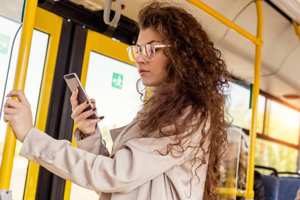 istock woman using smartphone in city bus 906343642