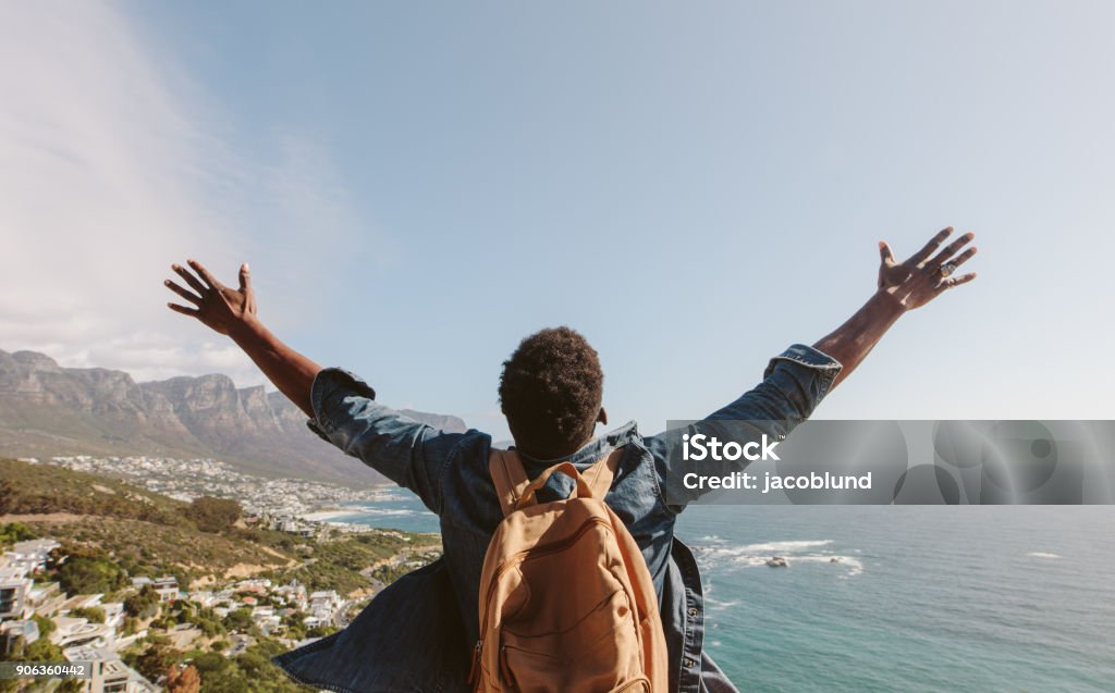 Hombre disfrutando de las vistas desde la cima de la montaña - Foto de stock de Hombres libre de derechos