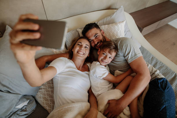 istock Family taking selfie on bed at home 906360754