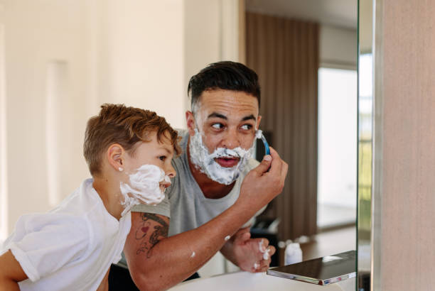 father and son shaving together in bathroom - shaving men shaving cream mirror imagens e fotografias de stock