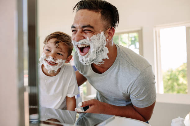 happy father and son having fun while shaving - shaving men shaving cream mirror imagens e fotografias de stock