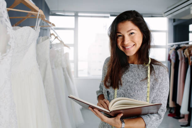 istock Beautiful female bridal store owner with a diary 906364280