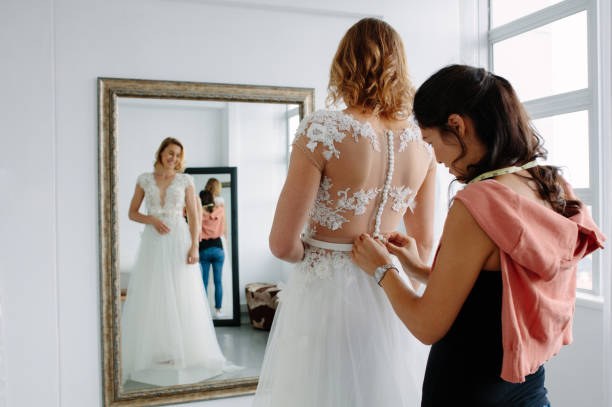 istock Wedding dress fitting in bridal boutique 906365524