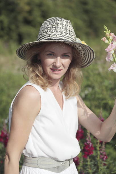 istock Young woman picking flowers at a farm. 906368980