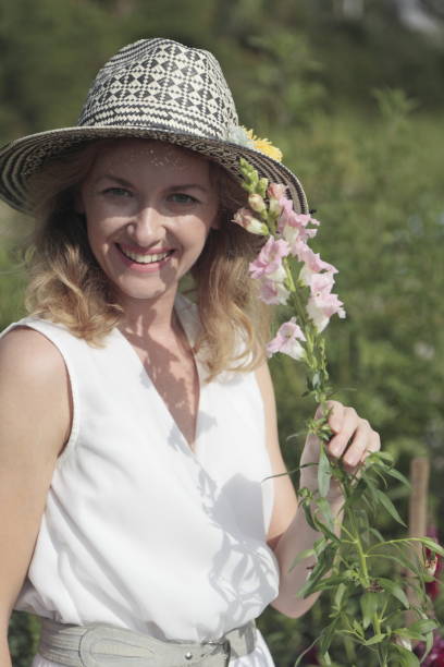 istock Young woman picking flowers at a farm. 906368996
