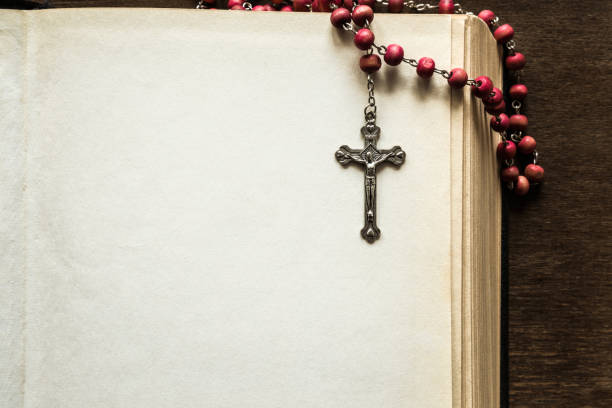 opened old thick bible with rosary beads on the brown table in the quiet, dark atmosphere. prayer time on sunday. empty place for text. religion concept. - prayer beads imagens e fotografias de stock