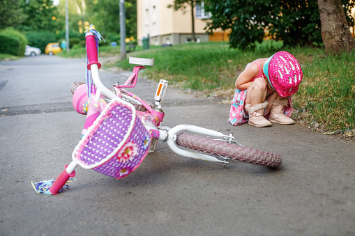 The child fell from a bicycle and cries. The concept of childhood and lifestyle.