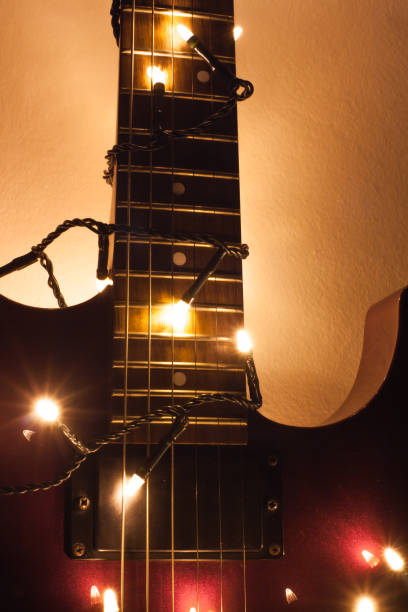 istock Guitar riff highlighted by new year lights in front of white background 906372600