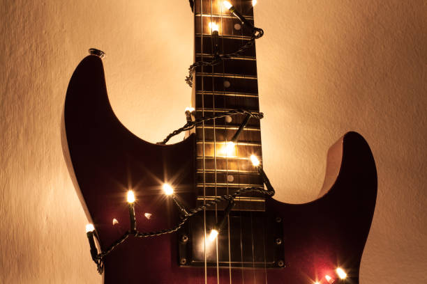 istock Guitar riff highlighted by new year lights in front of white background 906372640