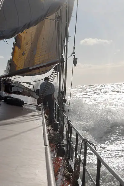 bow of a sailing-ship with waves and splashing water