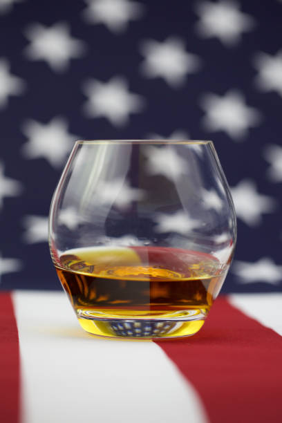 istock American Whiskey - whiskey on a flag background 906387710