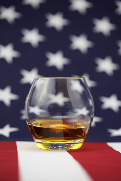 istock American Whiskey - whiskey on a flag background 906387752