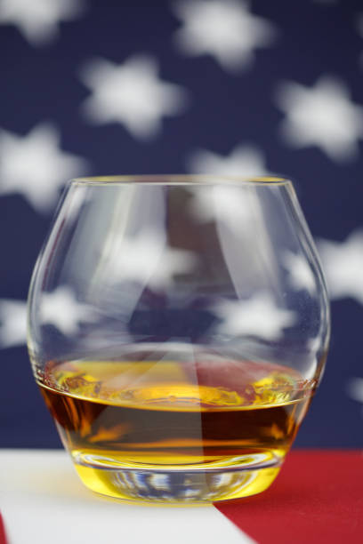 istock American Whiskey - whiskey on a flag background 906387818