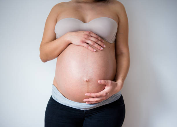 istock Woman posing with a pregnant belly 906396392