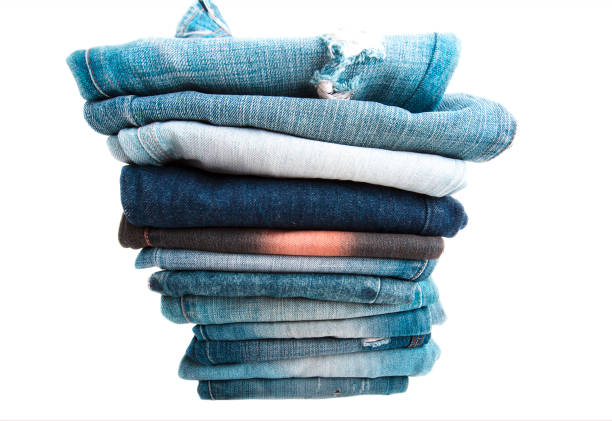 istock Stack of folded clothes, blue jeans pants, dark blue denim trousers on white background 906402560