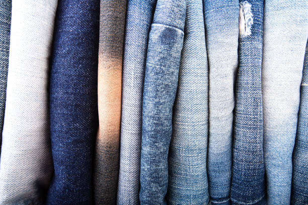 istock Stack of folded clothes, blue jeans pants, dark blue denim trousers on white background 906402578
