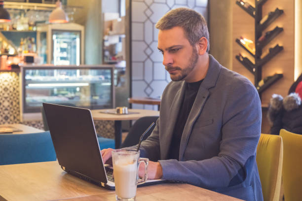 istock Businessman working in laptop in cafe 906410622