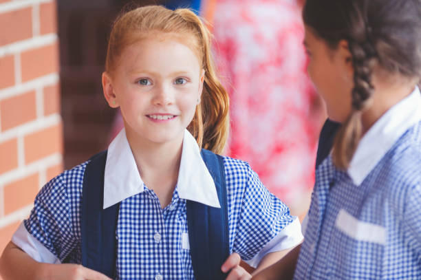 istock Schoolgirl in uniform with back pack. 906420208