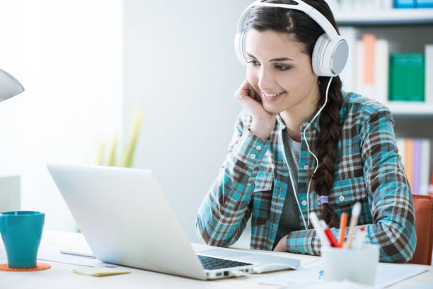 istock Girl with headphones using a laptop 906422686
