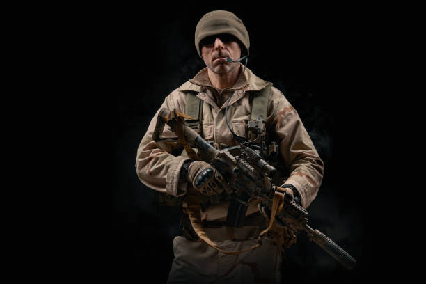 soldat des forces spéciales pose avec un fusil sur un fond noir - black ops photos et images de collection