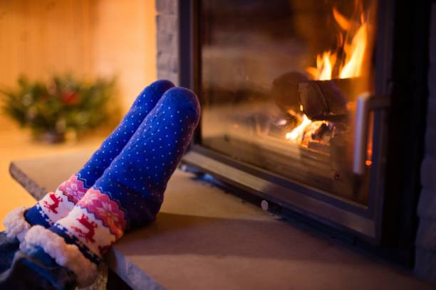 istock Child in woolen sock warming his feet 906423028