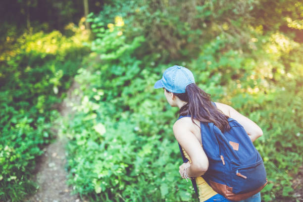 istock Girl trekking through forest 906423180