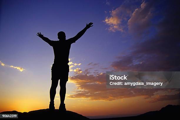 Silhouette Man With Arms Raised Into Sunset Sky Landscape Stock Photo - Download Image Now