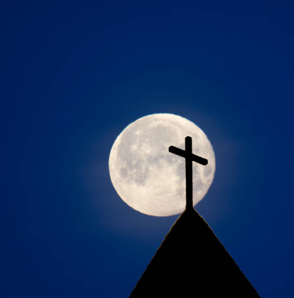 istock Church steeple silhouette and moon with copy space 906465214