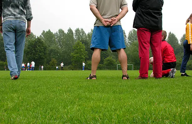 Photo of Various people watching a soccer game outdoors