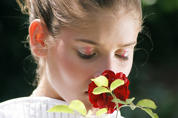 Studio shot of a beautiful young woman posing with white roses against her face