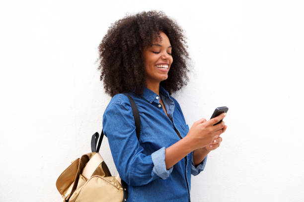 istock Smiling black woman with smart phone and backpack 906496318
