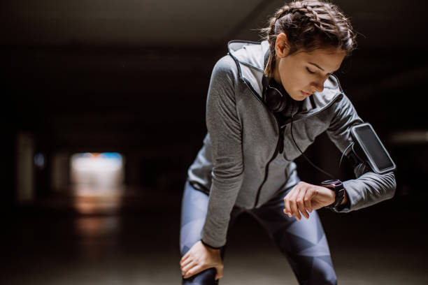 женщина мониторинга ее прогресса на smartwatch - jogging running taking pulse women стоковые фото и изображения