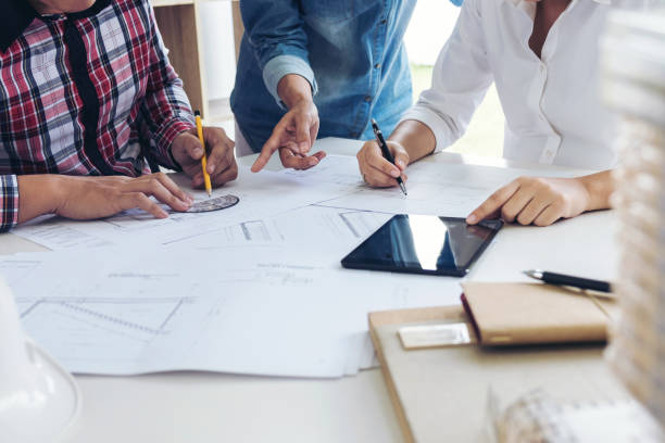 istock Architect working on blueprint, Engineer meeting working with partner colleagues and engineering tools for architectural project, Construction concept 906511764