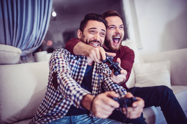 istock Two Excited Friends Playing Video Games 906514390