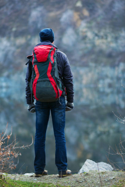 istock Traveler with a backpack is standing against the gray granite wall 906514576