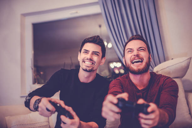istock Two Excited Friends Playing Video Games 906517552