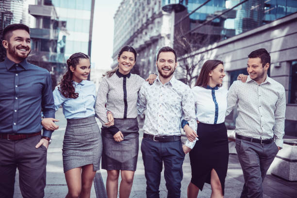 istock Group of Smiling Young Students Walking on the Street and Talking 906523032