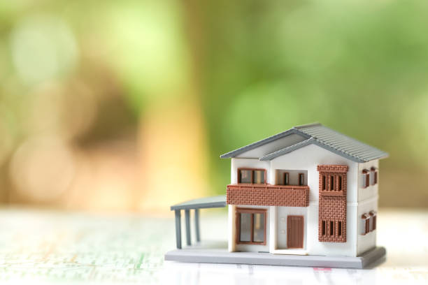 istock A model house model is placed on paper .as background real estate concept copy spaces for your text or design. 906535364